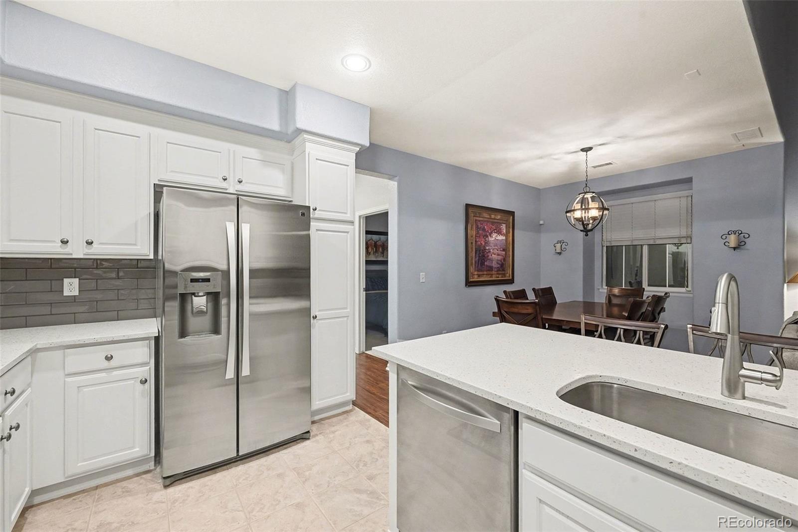 10546 Graymont Lane, Unit D Highlands Ranch, CO 80126 - Photo 11 of 21 a kitchen with a refrigerator sink and cabinets