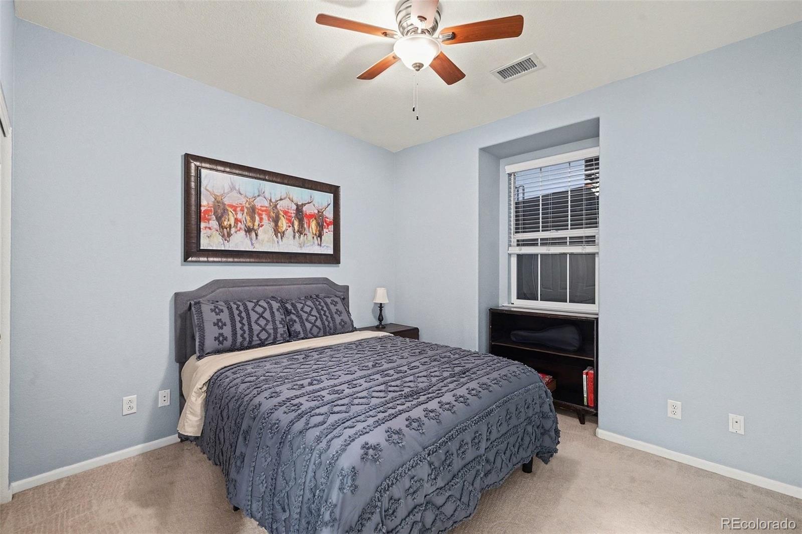 10546 Graymont Lane, Unit D Highlands Ranch, CO 80126 - Photo 19 of 21 a bedroom with a bed and a chandelier