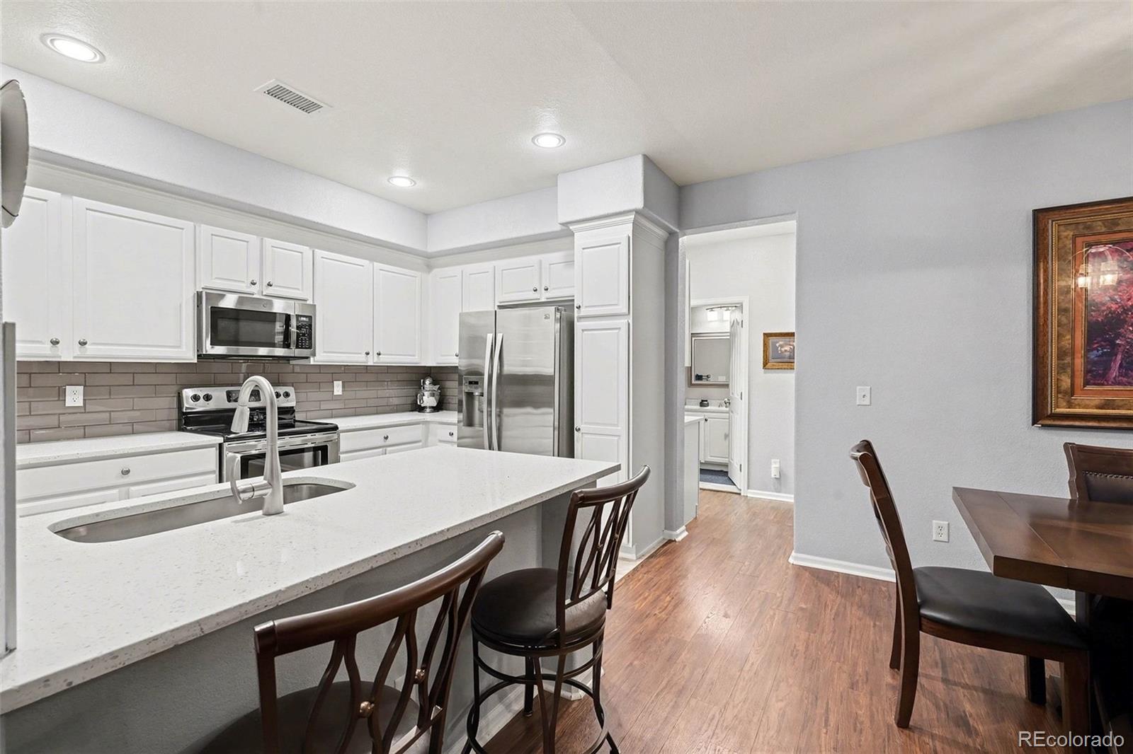10546 Graymont Lane, Unit D Highlands Ranch, CO 80126 - Photo 8 of 21 a kitchen with stainless steel appliances a dining table chairs microwave and sink