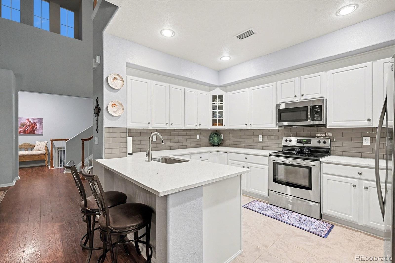 10546 Graymont Lane, Unit D Highlands Ranch, CO 80126 - Photo 9 of 21 a kitchen with a stove a sink and a microwave