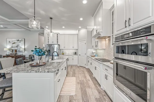 a large kitchen with stainless steel appliances kitchen island granite countertop a sink and cabinets