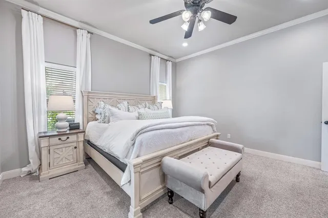 a bedroom with a bed lamp and a large window