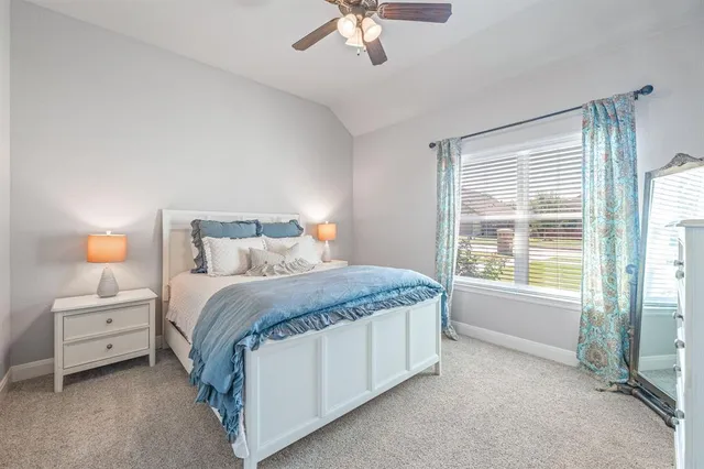 a spacious bedroom with a bed and a chandelier