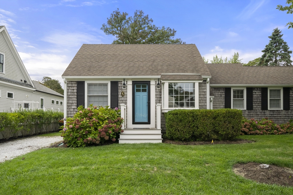24 Cross Street Harwich, MA 02646 - Photo 1 of 34 a house that is sitting in front of a big yard with potted plants