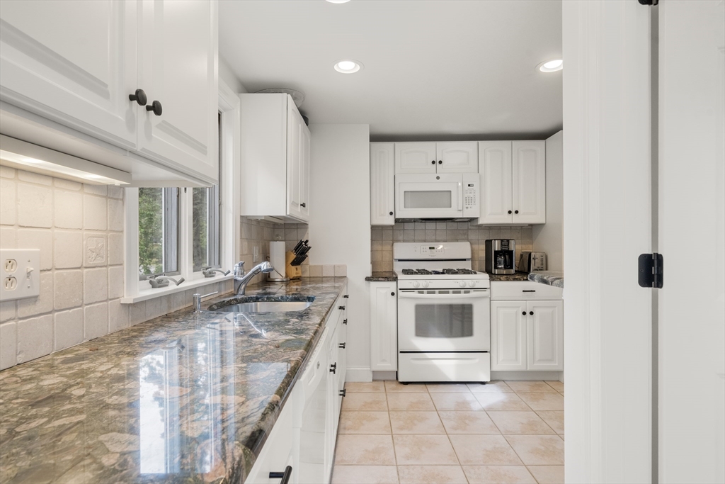 24 Cross Street Harwich, MA 02646 - Photo 11 of 34 a kitchen with kitchen island granite countertop a stove sink and cabinets