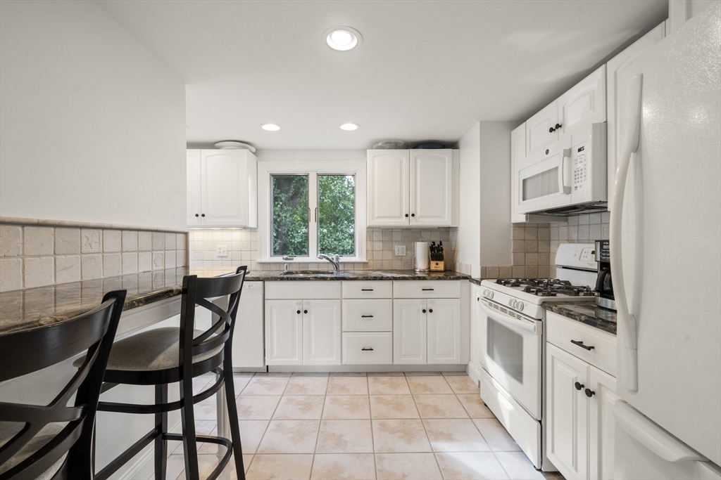 24 Cross Street Harwich, MA 02646 - Photo 8 of 34 a kitchen with stainless steel appliances granite countertop a table chairs sink and cabinets