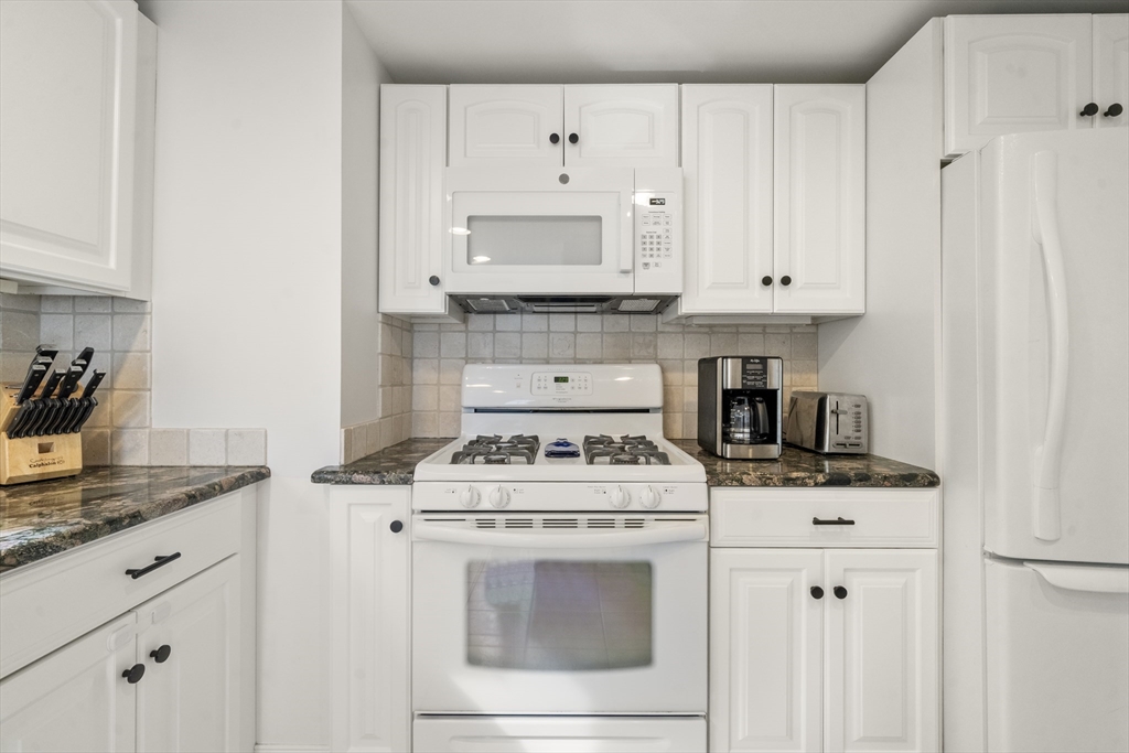 24 Cross Street Harwich, MA 02646 - Photo 10 of 34 a kitchen with cabinets and white appliances