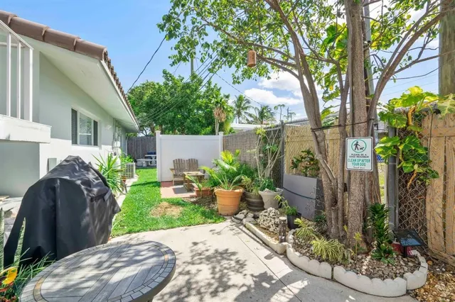 a view of a backyard with potted plants and large trees