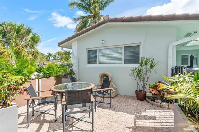 a backyard of a house with table and chairs