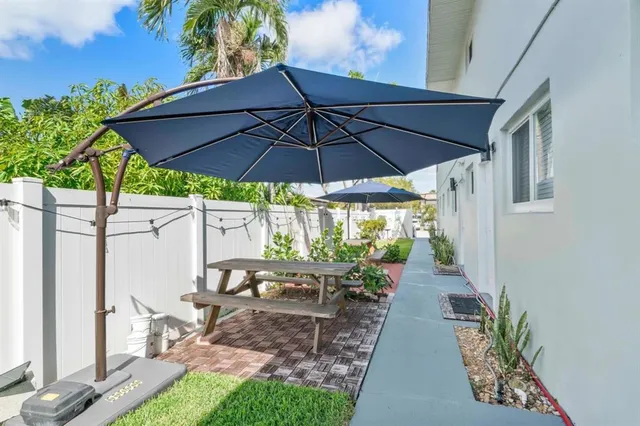 a view of a patio with chairs under an umbrella