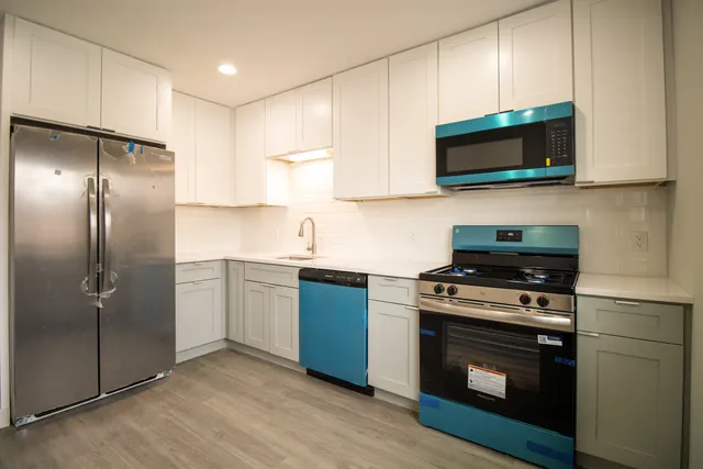 a kitchen with stainless steel appliances granite countertop a stove a microwave and a refrigerator