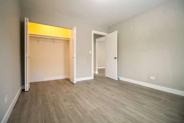 an empty room with wooden floor and closet