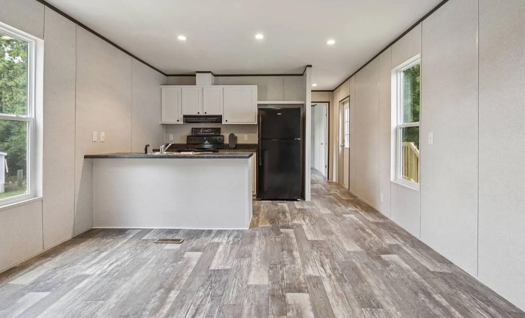 600 Ermine Road West Columbia, SC 29170 - Photo 7 of 20 Kitchen featuring a decorative wall, light wood-type flooring, a peninsula, black appliances, and white cabinetry