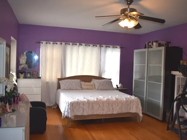 a bedroom with a bed dresser and a chandelier