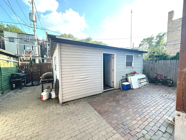 a view of a chair and table in the back yard of the house