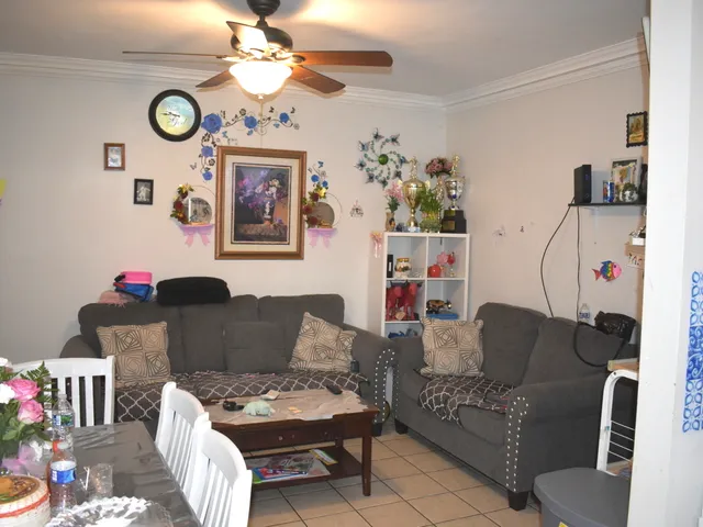 a living room with furniture a dining table and a chandelier