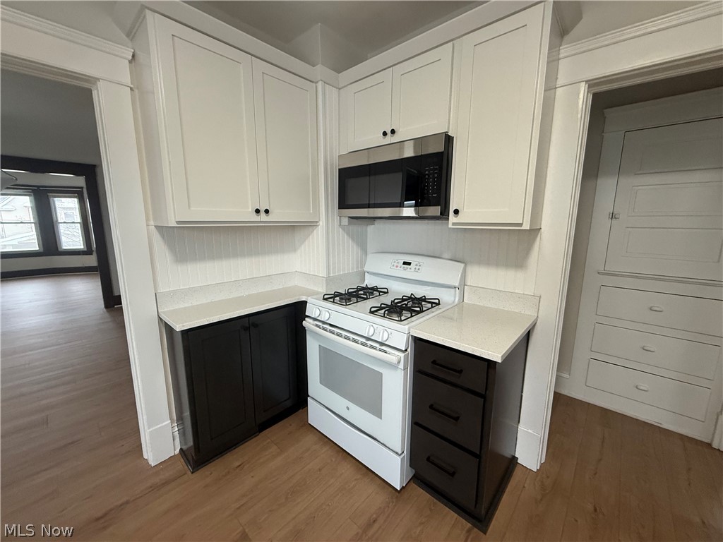 3612 Riverside Avenue Cleveland, OH 44109 - Photo 5 of 22 Compact kitchen area with white upper cabinetry, dark lower cabinetry, and light countertops
