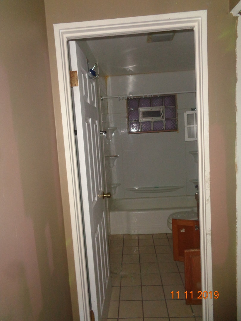 17331 Community Street Lansing, IL 60438 - Photo 7 of 9 a bathroom with a glass shower door