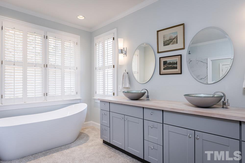 100 Edenburgh Road, Unit 203 Raleigh, NC 27608 - Photo 20 of 26 a bathroom with a tub a double vanity sink and a mirror