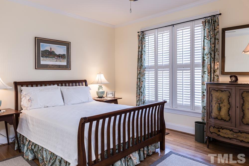 100 Edenburgh Road, Unit 203 Raleigh, NC 27608 - Photo 22 of 26 a bedroom with a bed next to a window with wooden floor