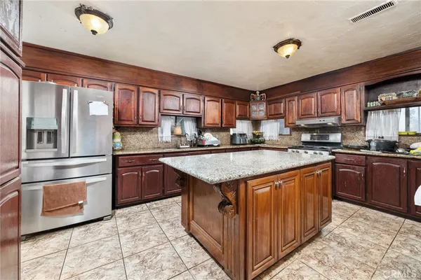 a kitchen with stainless steel appliances granite countertop a stove a sink dishwasher and a refrigerator