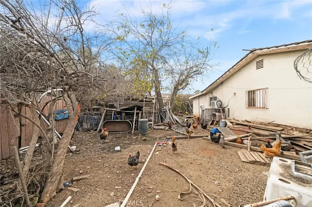 a view of a patio with table and chairs and a barbeque