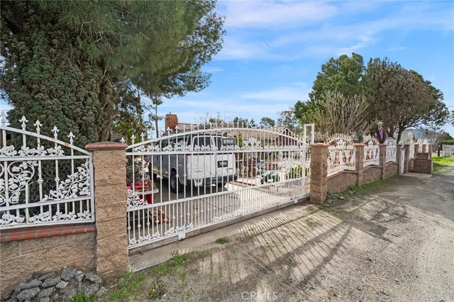 a view of a house with a small yard and wooden fence
