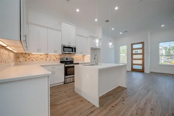 a kitchen with a refrigerator and a stove top oven