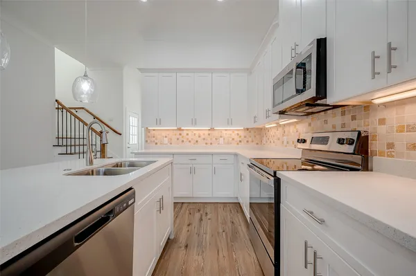 a kitchen with a sink stove and cabinets