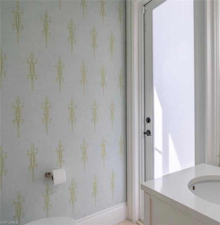 428 Rudder Road Naples, FL 34102 - Photo 29 of 47 Half bathroom with vanity and baseboards