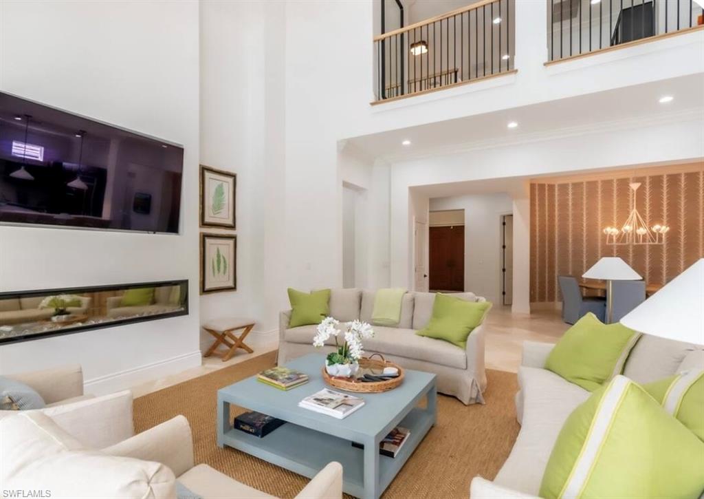 428 Rudder Road Naples, FL 34102 - Photo 5 of 47 Living room with a towering ceiling and a chandelier