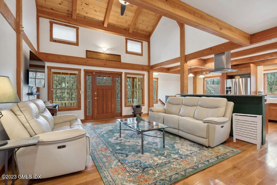 a living room with furniture a large window and wooden floor