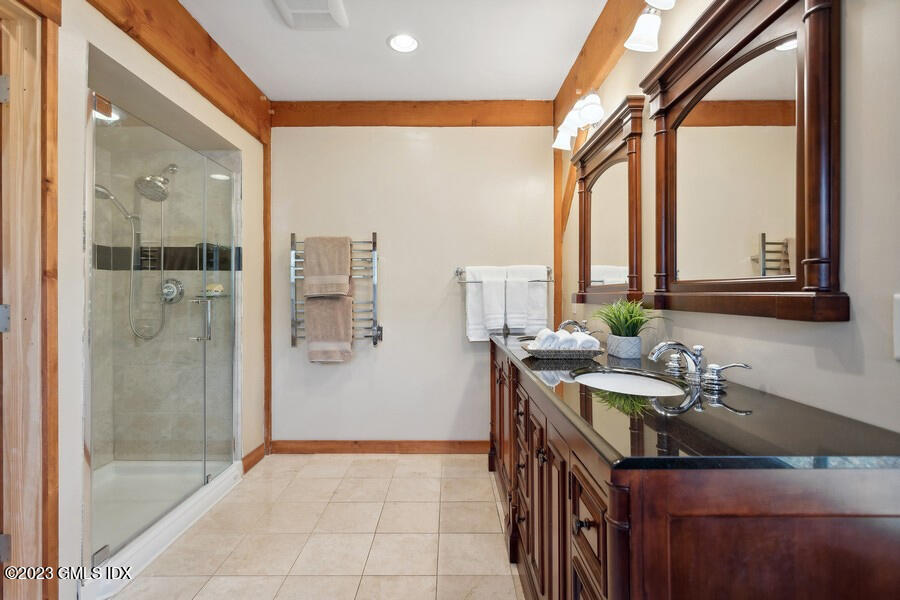 96 Cat Rock Road Cos Cob, CT 06807 - Photo 16 of 38 a bathroom with a sink a mirror and a shower