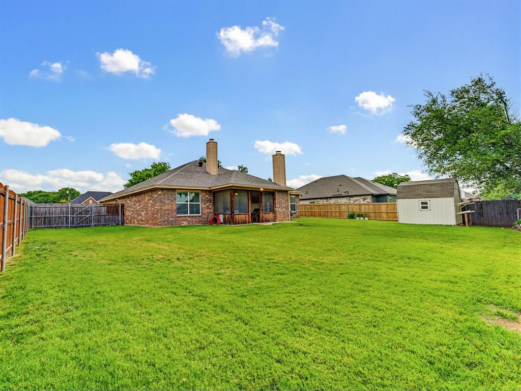 2108 Ridgewood Drive Bridgeport, TX 76426 - Photo 33 of 35 Expansive backyard featuring a manicured lawn, full privacy fencing, and a separate storage shed