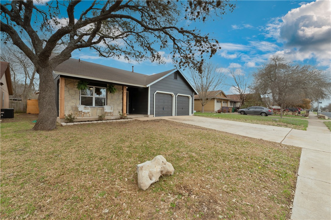 a yellow house with tree in front of it