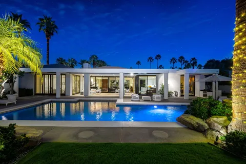 a view of a house with swimming pool and sitting area