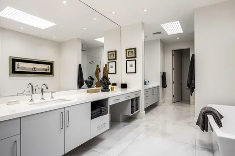 a front view of a house with garden and trees