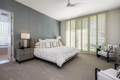 a front view of a house with a garden and swimming pool