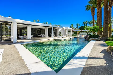 a view of a swimming pool with a yard and a fountain
