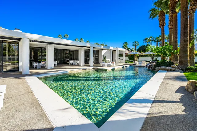 a view of a swimming pool with a yard and a fountain