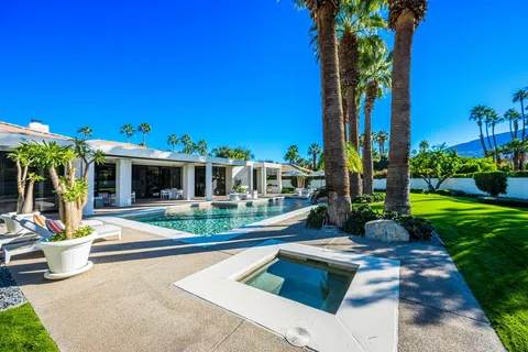 a view of a house with a swimming pool and sitting area