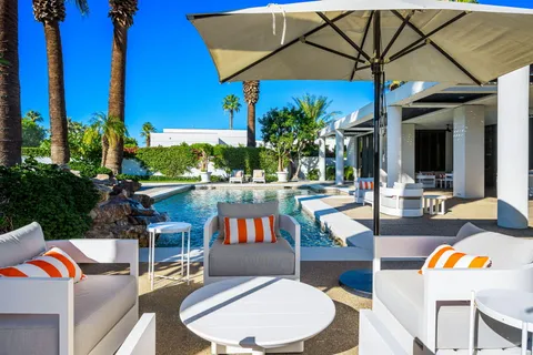 a view of backyard with swimming pool and outdoor seating