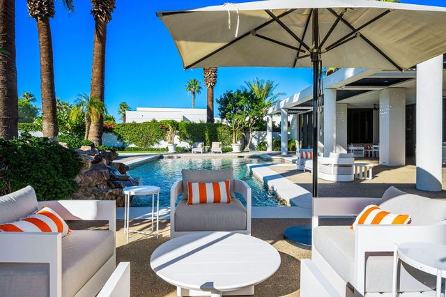 a view of backyard with swimming pool and outdoor seating