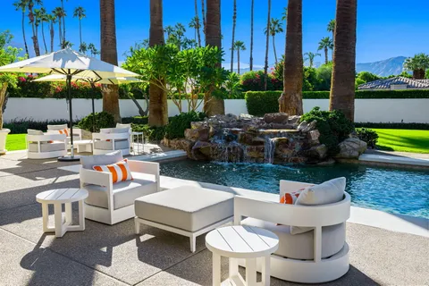 a front view of a house with garden and swimming pool