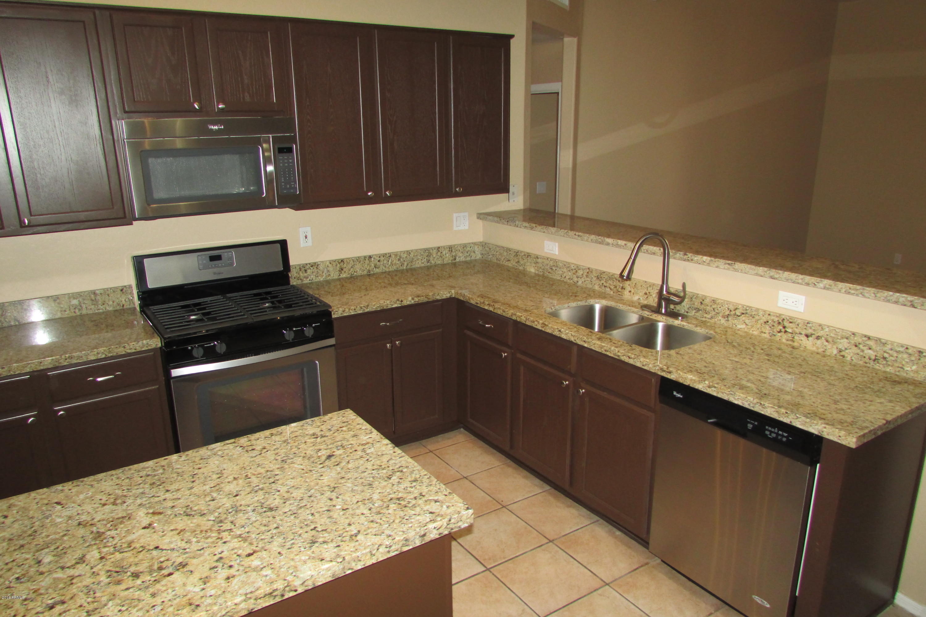 716 East Ranch Road Gilbert, AZ 85296 - Photo 7 of 22 a kitchen with a sink a stove top oven and wooden cabinets