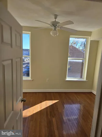 a view of a bedroom with wooden floor and windows