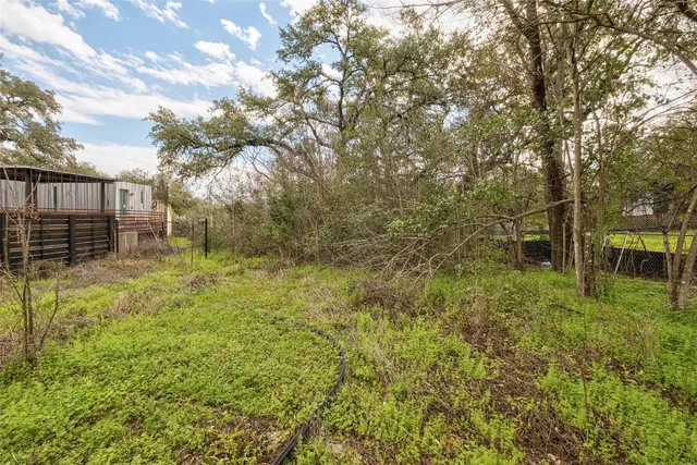 a backyard of a house with lots of green space and garden