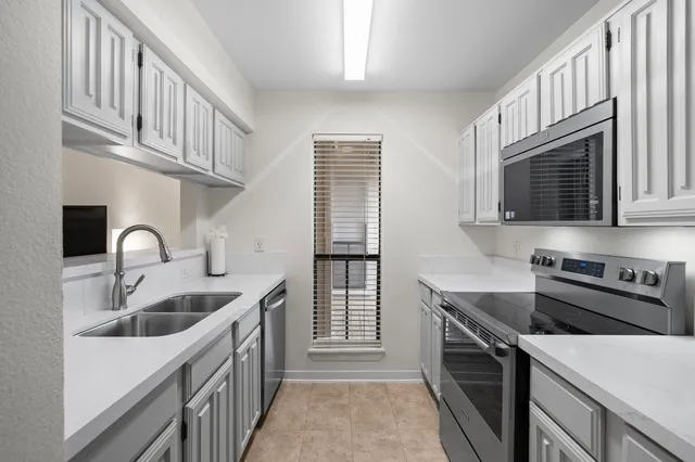 a kitchen with stainless steel appliances granite countertop a sink stove and cabinets