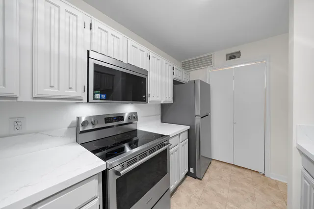 a kitchen with stainless steel appliances a refrigerator stove and microwave