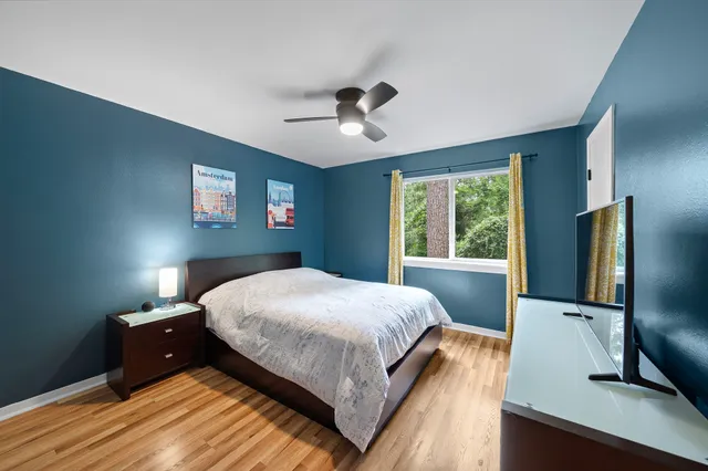 a bed room with a bed tv and a window